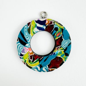 Peut inclure: Pendentif circulaire aux couleurs vives, orné d'un motif mosaïque. Il présente des touches de bleu, jaune, rouge et noir. Ce bijou unique est un accessoire de mode original.