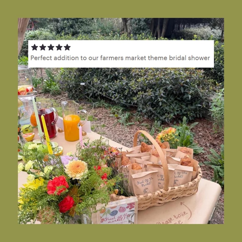Pode incluir: Uma cesta de vime tran&ccedil;ada cheia de pequenos sacos de papel contendo doces, cada um rotulado com o texto escrito &agrave; m&atilde;o 'Fresh Off The Market!'. Um arranjo floral colorido, jarras de vidro com suco de laranja e vermelho, e velas por perto.