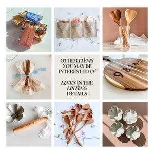 May include: A collection of kitchen and home decor items. Includes wooden heart-shaped spoons, a wooden cutting board with numbers, decorative matchboxes, and small ceramic bowls. Some items have text, including "Let's Celebrate".