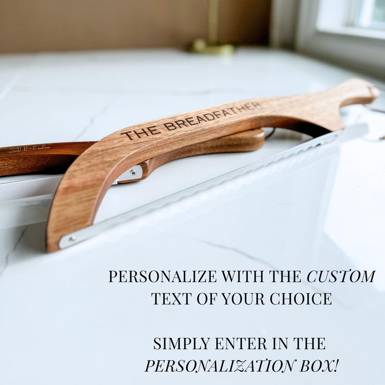 May include: A wooden bread slicer with a stainless steel blade. The words "THE BREADFATHER" are engraved on the wooden handle. The image also includes the text "PERSONALIZE WITH THE CUSTOM TEXT OF YOUR CHOICE" and "SIMPLY ENTER IN THE PERSONALIZATION BOX!"