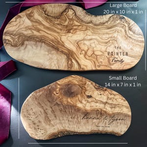 May include: Two wooden serving boards with natural wood grain patterns. The larger board is 20 inches long, 10 inches wide, and 1 inch thick, with "THE POINTER Family" engraved. The smaller board, 14 x 7 x 1 inches, is engraved with "hanna & tyson" and "MAY 22, 2026".