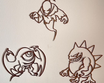 May include: Three wooden wall art pieces featuring cartoon monster designs. The set includes a ghost-like figure, a one-eyed creature with wings, and a spiky-backed monster with a wide grin. The art pieces are brown and mounted on a white wall.