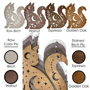 May include: A collection of laser-cut wooden cat silhouettes featuring celestial moon, star, and mushroom cutouts. The display includes four distinct wood finishes labeled Raw Birch, Walnut, Espresso, and Golden Oak, with circular color swatches.