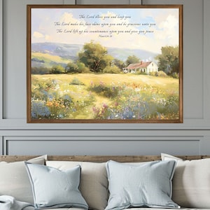 May include: A framed print of a painting depicting a rural landscape with a white farmhouse in the distance. The painting features a field of wildflowers and rolling hills. The print includes a bible verse: "The Lord bless you and keep you. The Lord make his face shine upon you and be gracious unto you. The Lord lift up his countenance upon you and give you peace. Numbers 6:24-26."