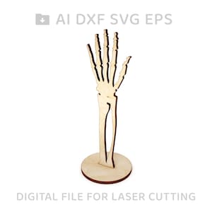 May include: A wooden skeleton hand cutout with a base. The hand is raised with fingers extended. The cutout is for laser cutting.