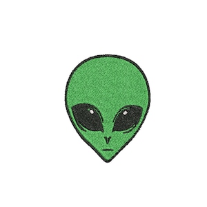 May include: Green alien face with black eyes and a frown. The alien is embroidered on a white background.