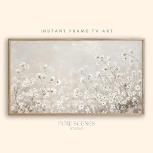 Könnte beinhalten: Ein rechteckiges gerahmtes Wandbild mit dem Titel INSTANT FRAME TV ART von PURE SCENES STUDIO. Das Kunstwerk zeigt ein Gemälde in sanften, neutralen Tönen mit zarten weißen Wildblumen vor einem verschwommenen, hellbeigen Hintergrund in einem Holzrahmen.