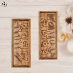 May include: Two wooden serving trays with a carved wave pattern. The trays are rectangular and have a light brown color.