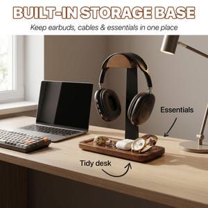 May include: A wooden headphone stand with a built-in storage base featuring a vertical support and a rectangular tray. The text reads BUILT-IN STORAGE BASE, Keep earbuds, cables & essentials in one place, Essentials, and Tidy desk.