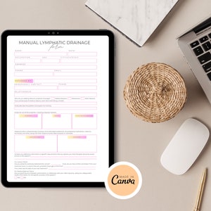 May include: A digital form titled "Manual Lymphatic Drainage Form" with fields for name, occupation, age, date, and other information. The form is on a tablet computer and is surrounded by a white surface, a laptop computer, a woven coaster, a white mouse, and a gold pen.