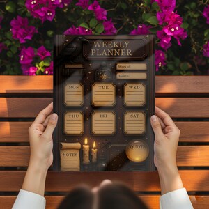 Two hands hold the Mystical Weekly Planner over a brown wooden bench, with bright pink bougainvillea flowers in the background. The Witchy Weekly Schedule design provides a mystical backdrop for planning tasks.