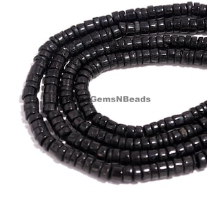 May include: A close-up shot of a string of black, square beads. The beads are strung together, creating a flexible line. The surface of the beads is smooth and reflective. The image includes the text "GemsNBeads".