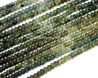 May include: A strand of green and blue gemstone beads. The beads are small and round, with a slightly irregular shape. They have a translucent appearance, with some showing a hint of sparkle.