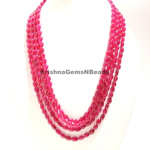 May include: A multi-strand necklace made of oval-shaped, pink gemstone beads. The necklace is approximately 18 inches long and features a total of five strands of beads.