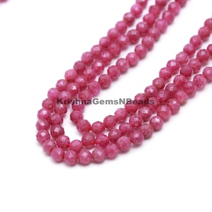Könnte beinhalten: Eine Strähne aus rosafarbenen facettierten Edelsteinperlen. Die Perlen sind rund und haben eine glatte, polierte Oberfläche. Die Strähne ist etwa 45 cm lang.