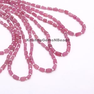 Puede incluir: Una hebra de cuentas de piedras preciosas rosas con separadores blancos. Las cuentas son facetadas y tienen una forma ligeramente irregular. La hebra mide aproximadamente 45 cm de largo.  KrishnaGemsNBeads