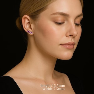 Pode incluir: Brincos de pressão com um design de três pétalas em magenta com contorno prateado. Os brincos medem 1,55 cm de altura e 0,75 cm de largura. São exibidos numa orelha sobre um fundo preto, realçando o design da joia.