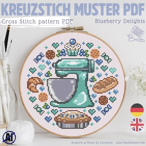 May include: A cross-stitch pattern PDF titled "Blueberry Delights" features a teal stand mixer, baked goods, and blueberries. The design is framed in a wooden embroidery hoop. Text includes "KREUZSTICH MUSTER PDF" and "Cross Stitch pattern PDF".