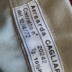 May include: White label with black text that reads "Aersarda CAGLIARI" and "Contratto n. 20242" and "del 12/4/72" and "Tg. 16 1/2R"