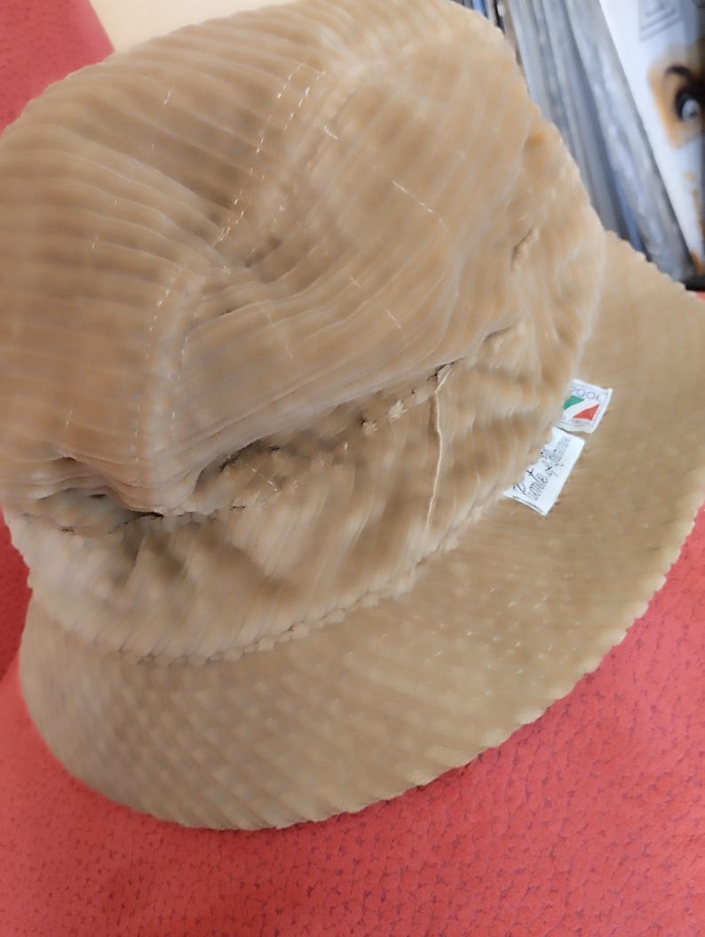 May include: A beige corduroy bucket hat with a small label that reads "Made in Italy".