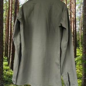 May include: A long-sleeved, olive green utility shirt with a button-up front and a pointed collar.