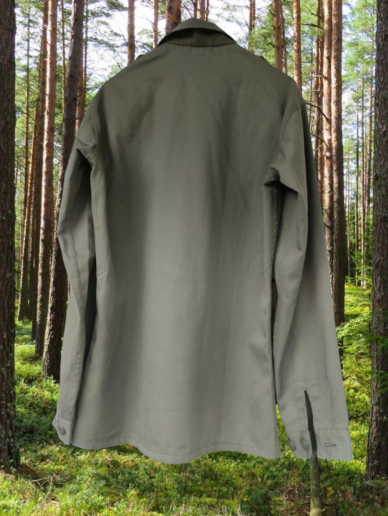 May include: A long-sleeved, olive green utility shirt with a button-up front and a pointed collar.