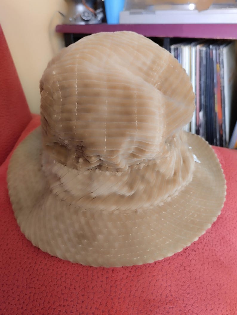 May include: A beige corduroy bucket hat with a wide brim. The hat has a textured, ribbed surface.