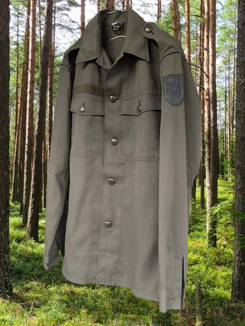 May include: A green military-style shirt with a patch on the sleeve that reads "Bundeswehr".