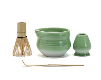 May include: A green ceramic matcha bowl, a bamboo whisk, a green ceramic matcha cup, and a bamboo matcha scoop.