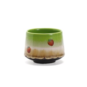 May include: A green ceramic teacup with a brown rim and a white band. The cup is decorated with red strawberries.