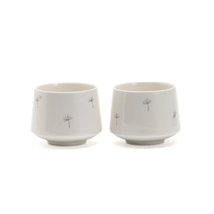Può includere: Due tazze in ceramica bianca con un design a dente di leone. Le tazze hanno una base larga e un bordo leggermente svasato.