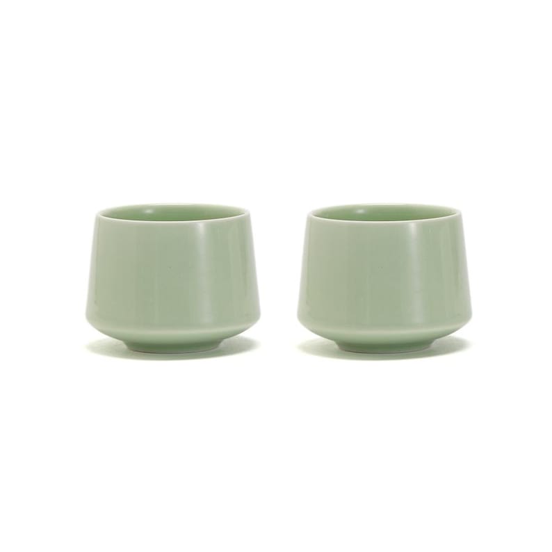 May include: Two pale green ceramic cups with a rounded bottom and a slightly flared lip.