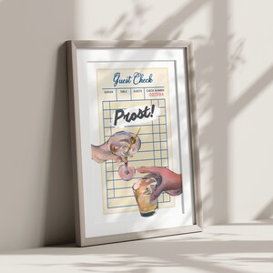 May include: A framed illustration of two hands clinking glasses, one holding a martini and the other a glass of whisky. The background is a vintage-style guest check with the word "Prost!" written in blue.