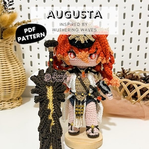 Può includere: Bambola Augusta all'uncinetto, ispirata a Wuthering Waves, con capelli rossi e un abito dettagliato. La bambola tiene in mano una grande spada marrone scuro e dorata. L'immagine include il testo "PDF Pattern".