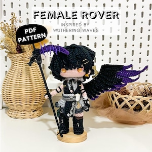 May include: A crocheted doll of a character with black hair, purple accents, and black wings. The doll is holding a staff and is inspired by "Wuthering Waves." The text "FEMALE ROVER" and "PDF PATTERN" are visible.