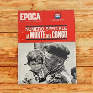 May include: Vintage Italian magazine cover with the title "Numero Speciale La Morte Nel Congo" in large white letters on a red background. The cover features a black and white photograph of a man in uniform holding a child.