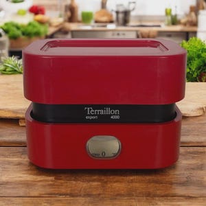 Può includere: Una bilancia da cucina rossa con una fascia nera e un display digitale. Sulla bilancia è stampata la scritta "Terraillon export 4000". La bilancia è appoggiata su una superficie di legno.