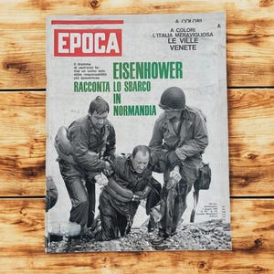 May include: A vintage magazine cover featuring the headline "EISENHOWER RACCONTA LO SBARCO IN NORMANDIA" in green text. The cover shows three men in military uniforms, with the magazine title "EPOCA" in red.