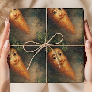 May include: A wrapped gift box featuring a whimsical design of smiling anthropomorphic carrots. The box is tied with twine and a bow. The carrots are orange with green tops, set against a dark green background.