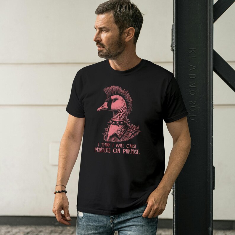May include: A black t-shirt with a pink punk rock goose graphic and the text "I think I will cause problems on purpose."
