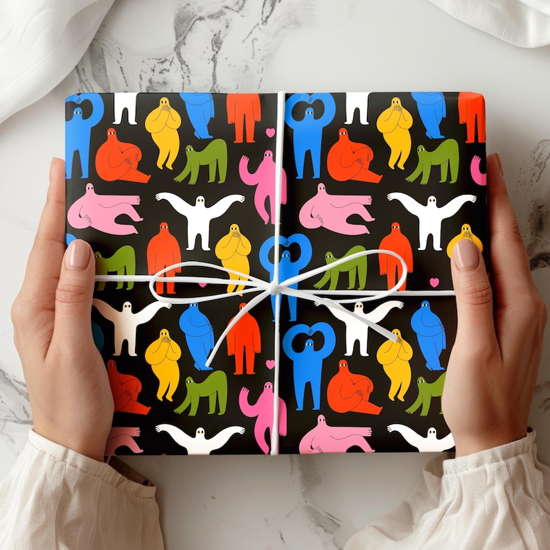 May include: A wrapped gift with a black background and a colorful pattern of abstract human figures in various poses. The figures are in shades of red, blue, yellow, green, pink, and white. The gift is tied with a white ribbon.