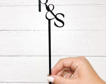 May include: Black acrylic cocktail stirrer with the letters R & S intertwined.