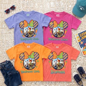 K&ouml;nnte beinhalten: Vier kurz&auml;rmelige T-Shirts mit Rundhalsausschnitt in Helllila, Pink, Orange und Koralle. Jedes zeigt eine Grafik mit Mausohren-Silhouette, Zootopia-Figuren, einer gr&uuml;nen Schleife mit Karottenmuster sowie dem Text Birthday Girl, Birthday Crew oder Sophia.