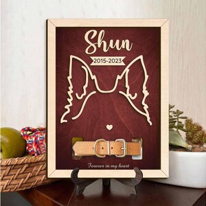 May include: Wooden memorial plaque with a red background and a cutout of a dog's head. The plaque reads "Shun 2015-2023" and "Forever in my heart". A brown leather dog collar is included.