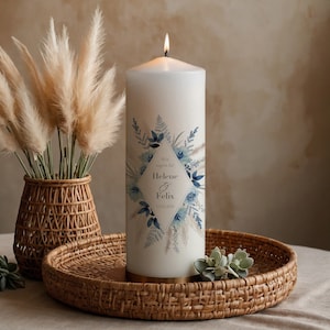 Könnte beinhalten: Eine weiße Stumpenkerze mit einem blauen und weißen Blumenmuster und dem Text "Wir sagen ja! Helene & Felix 11.02.2023".