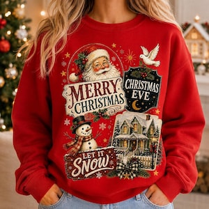 May include: A red long-sleeve sweatshirt featuring a graphic print of Santa Claus, a snowman, and a house. The text reads Merry Christmas, Christmas Eve, and Let It Snow. The design includes a white dove, stars, and snowflakes on a red background.