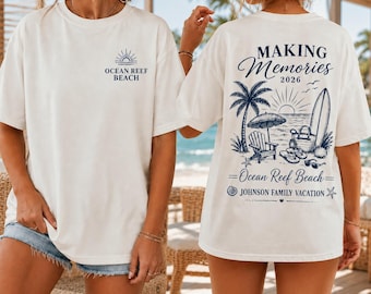 May include: A white t-shirt featuring a small navy blue graphic on the front that reads Ocean Reef Beach with a sun icon. The back displays a large navy blue graphic with the text Making Memories 2026, Ocean Reef Beach, and Johnson Family Vacation.