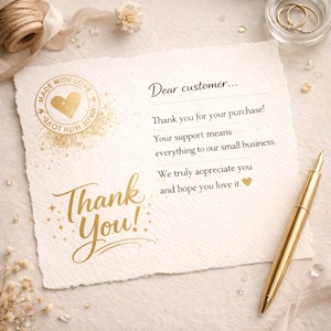 May include: A thank you card with gold foil lettering and accents. The card reads "Thank You!" and "Dear customer... Thank you for your purchase!" A gold pen and a small dish with rings are also visible.