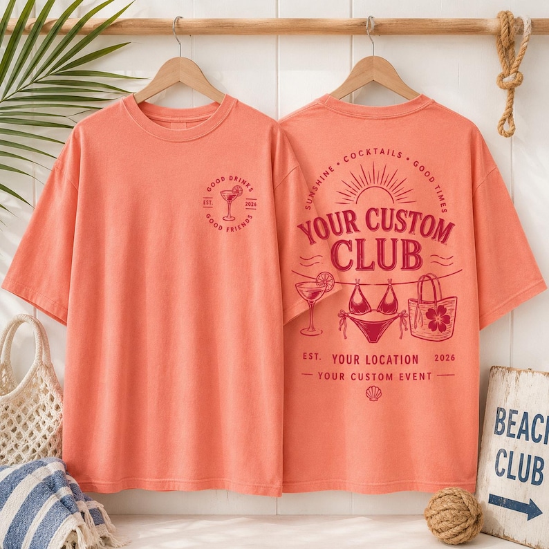 May include: A coral-colored t-shirt featuring a small graphic on the front left chest with a cocktail glass and the text Good Drinks Good Friends Est 2024. The back displays a large graphic with the text Your Custom Club, Sunshine, Cocktails, Good Times, Your Location, 2026, and Your Custom Event, alongside illustrations of a cocktail, a bikini, and a tote bag.