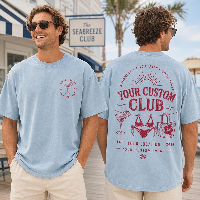 May include: A light blue short-sleeve t-shirt featuring a small red graphic on the front chest and a large red graphic on the back. The back design includes a cocktail, bikini, and tote bag with the text YOUR CUSTOM CLUB, YOUR LOCATION, and 2026.